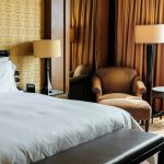 Hotel room interior with bed, bedside tables, armchair and lamps from a hotel furniture list for new hotel projects