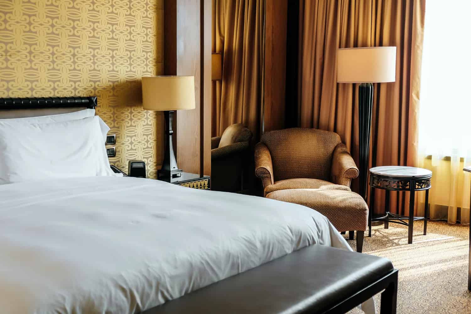 Hotel room interior with bed, bedside tables, armchair and lamps from a hotel furniture list for new hotel projects